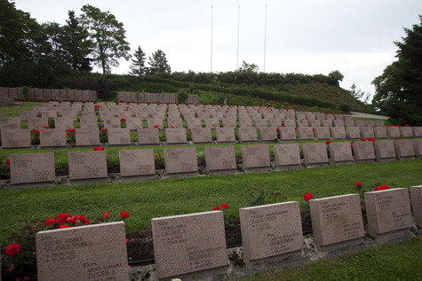 Joillekin sankarihaudan hautakiville on juuri asetettu punaisia kukkia.