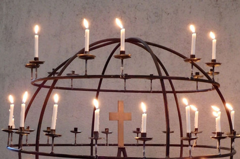 Kirkon rukouskynttilät pallon muotoisessa telineessä.