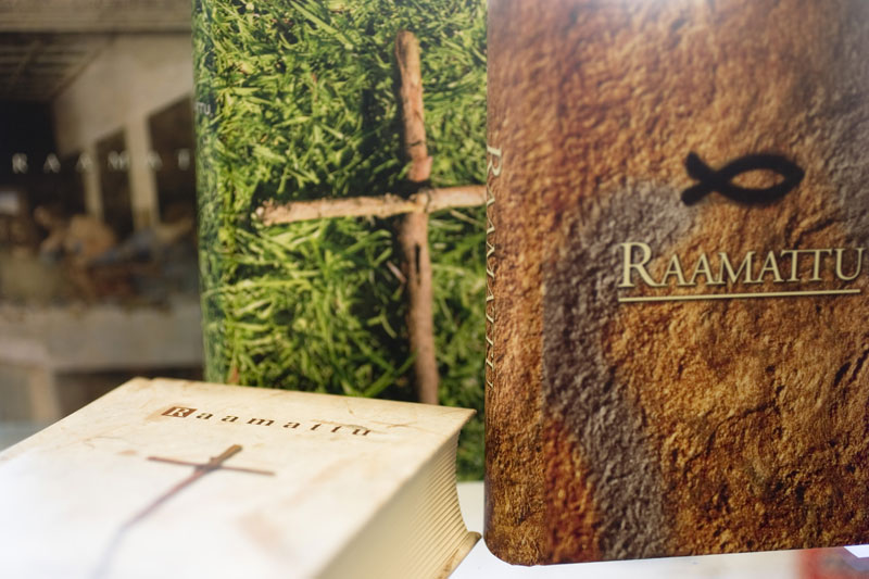 Kolme Raamattua, joissa on luontoaiheinen kansigrafiikka, on asetettu esille.