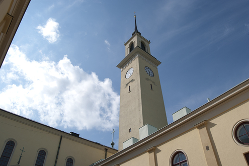 Viinikan kirkon keltainen korkea kellotapuli halkoo sinistä kesäistä taivasta.