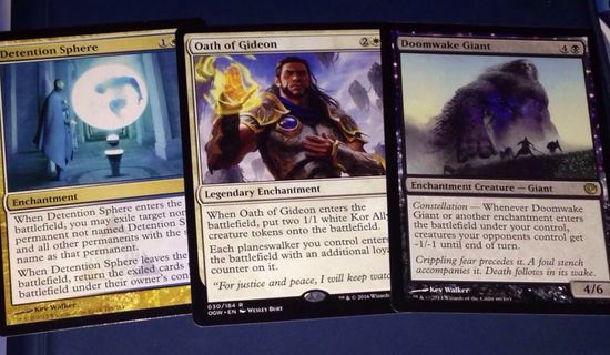 Kolme Magic of the Gathering-korttia pöydällä.