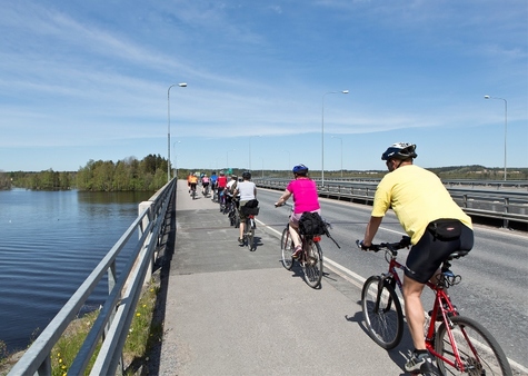 Kirkkopyöräilyyn osallistuvat pyöräilijät ylittävät letkassa Rajasalmen siltaa.