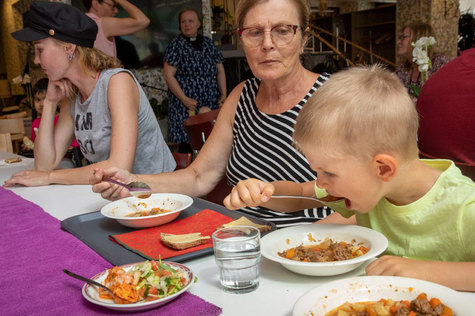 Nuori poika ja aikuinen nainen ovat saapuneet ruokailemaan Mummon Kammarin kesäruokailuun.
