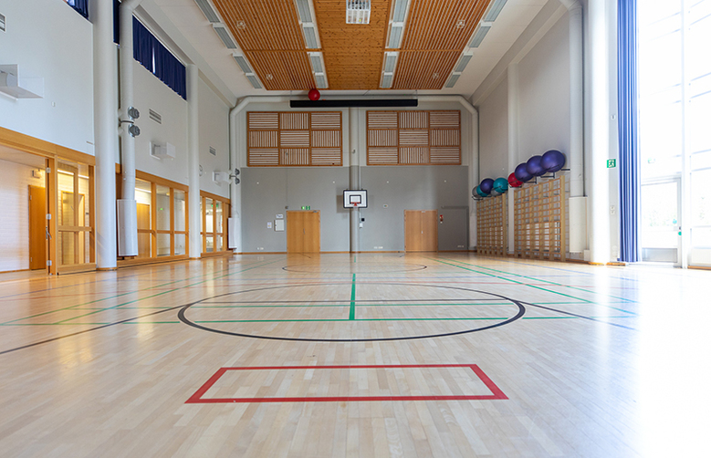 AitO-keskuksen perinteisessä liikuntasalissa on venyttely- ja kiipeilypuu sekä jumppapalloja.