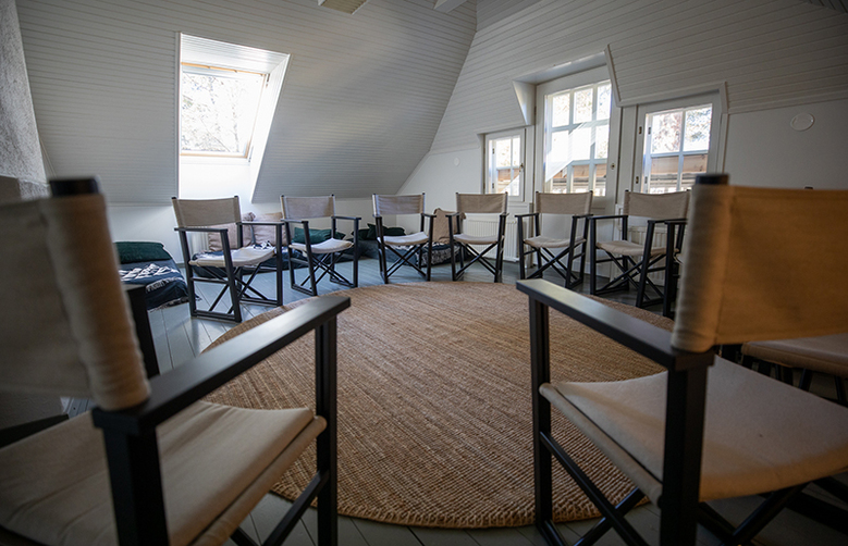 Virkkulan retriittihuoneen keskelle on asetettu pyöreä matto ja maton ympärille tuoleja rinkiin.
