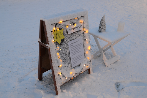 Luminen ilmoitus ständi, johon on laitettu jouluvalot kiinni.