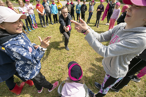 Kesäleiriläiset leikkivät nurmikentällä.