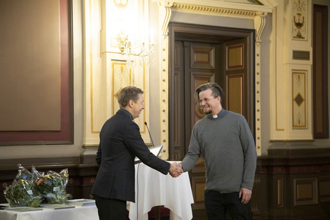 Apulaispormestari Matti Helimo kättelee pastori Olli Viljakaista Raatihuoneella.