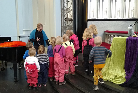 Lapsiryhmä tutustumassa Viinikan kirkon alttarin edustalla.