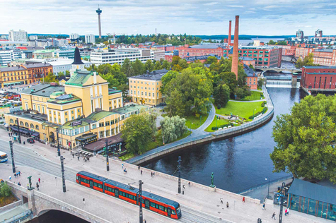 Kesäinen ilmakuvan Finlaysonin katolta Tammerkoskelle etelän suuntaan, jossa Tammerkoskea ympäräivät punatiiliset rakennukset.