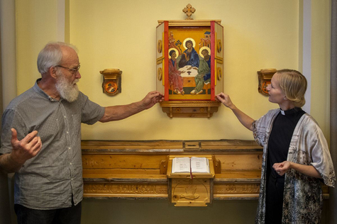 Vesa Fabrin ja Riikka Mattila avaamassa seinällä olevan ikonin sivusiivekkeitä.