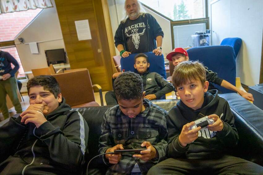 Children playing console games at a church hobby club.