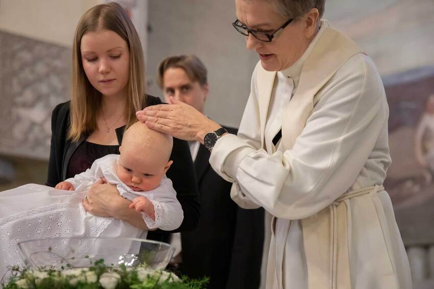 Pappi kastaa sylissä olevaa vauvaa.