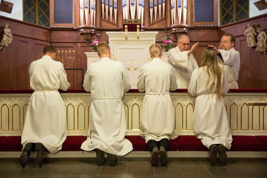 Young adults who participated in the adult confirmation class are blessed at the altar of Finlayson Church.