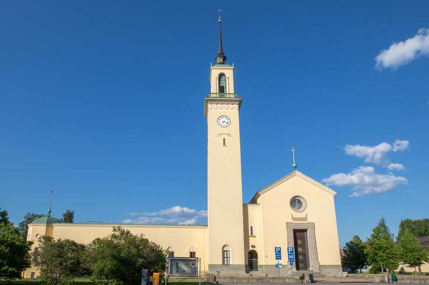 Viinikan kirkon korkea keltainen kellotapuli halkoo sinistä taivasta.