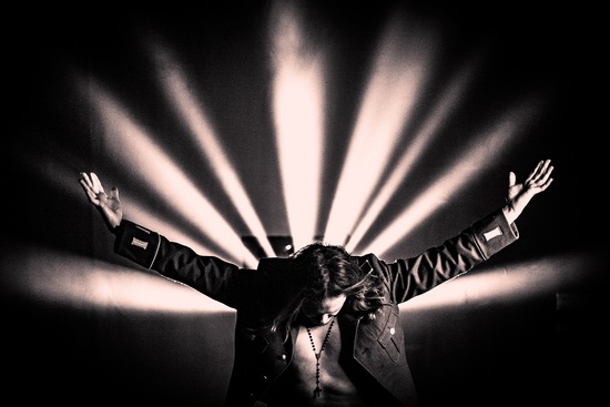 Jonne Aaron kumartaa, valonsäteet taustalla.