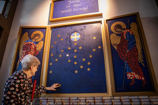 Nainen koskettaa maalauksen tähteä taulujen muodostamassa maalauskokonaisuudessa.