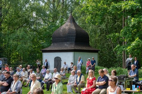 Ihmisiä viettämässä messua ulkoilmassa Gaddin kappelilla aurinkoisella säällä.