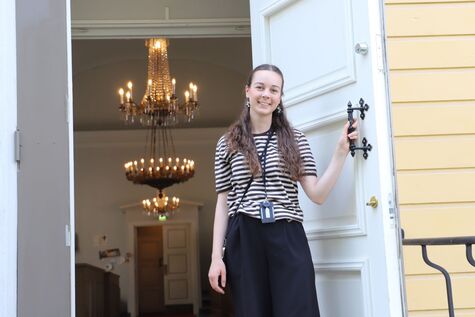 Vanhan kirkon opas Iida Repo kuvattuna Vanhan kirkon ovella kesällä 2025.