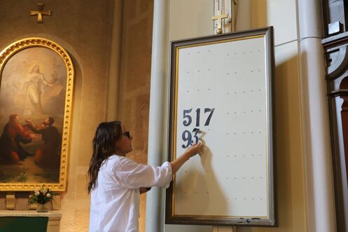 Vahtimestari laittaa virsinumeroita paikalleen Aleksanterin kirkossa.