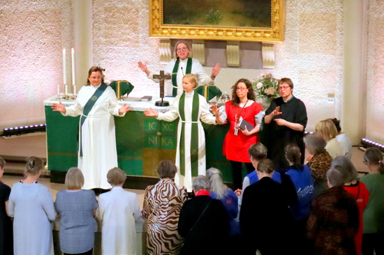 Alttarille on polvistunut iso joukko vapaaehtoisia, joita siunataan tehtäviinsä.