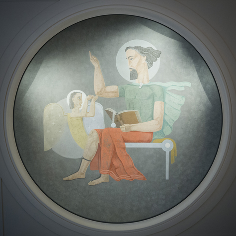 Kattomaalauksessa mies istuu penkillä, lukee kirjaa, osoittaa sormellaan, ja hänen vieressään on enkeli.