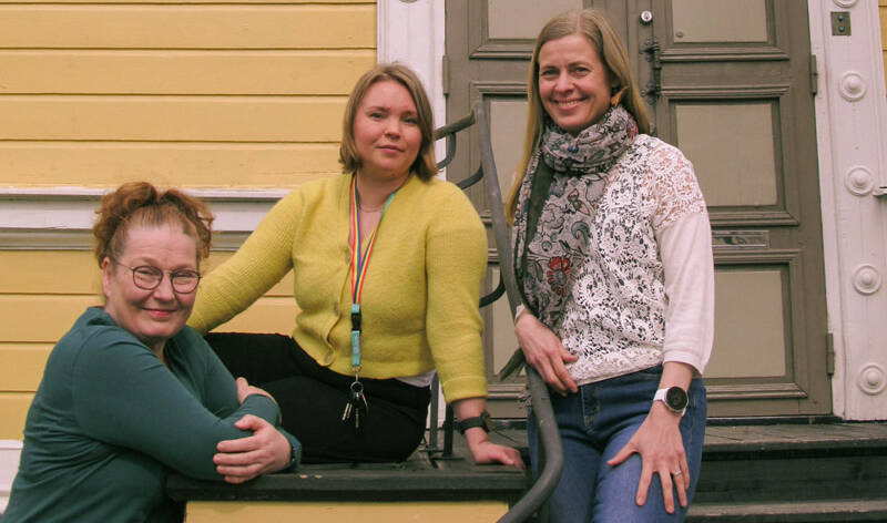Kuvassa kolme henkilöä Vanhan kirkon edustalla.