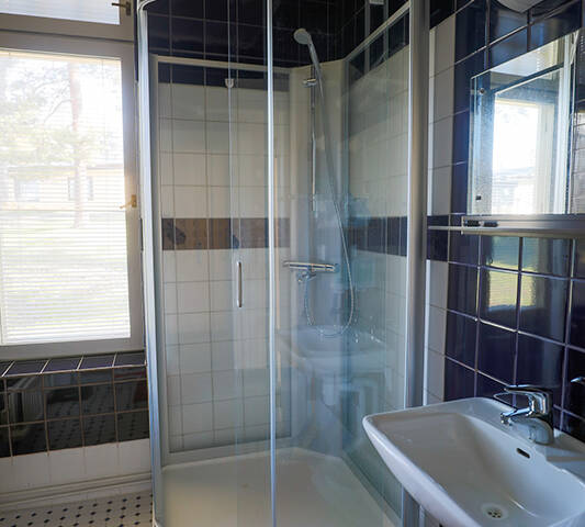Huvilan suihkutilassa on hieno, uusi suihkukaappi. Kaakelointi on selvästi uusittu. Mustat ja valkoiset kaakelit luovat tyylikkään, vanhanaikaisen tunnelman. Tila näyttää hyvältä ja asiallisesti hoidetulta.