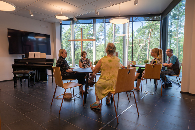 Seurakuntatila Auneksen alakertaan on kokoontunut ihmisiä.