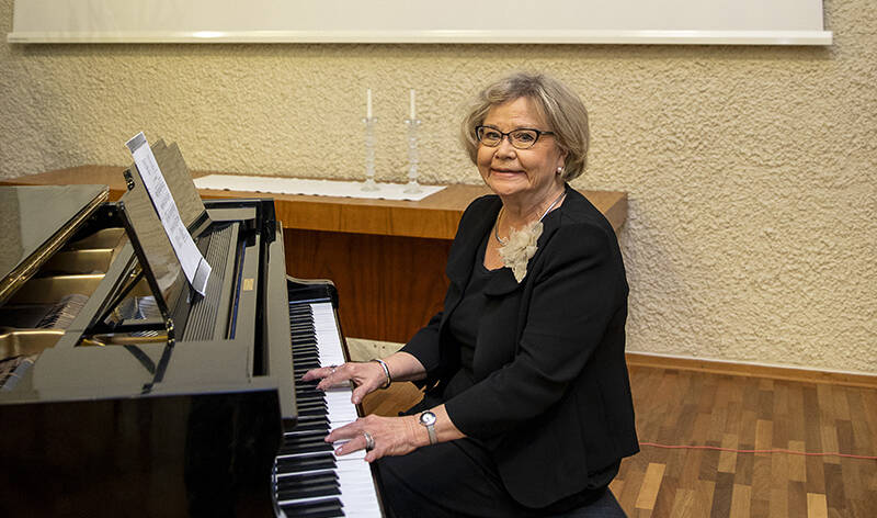 Eeva-Liisa Erkkilä haluaa rohkaista musiikinharrastajia mukaan Soivaa hoivaa -hankkeeseen. Erkkilä istuu Näsin salin flyygelin äärellä ja hymyilee.