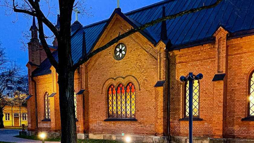Tampereen Finlaysonin kirkko, punatiilinen kirkko syksyisessä aamuhämärässä.