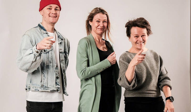 Kaksi näyttelijää ja ohjaaja hymyilevät.