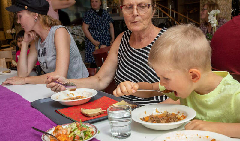 Nuori poika ja aikuinen nainen ovat saapuneet ruokailemaan Mummon Kammarin kesäruokailuun.