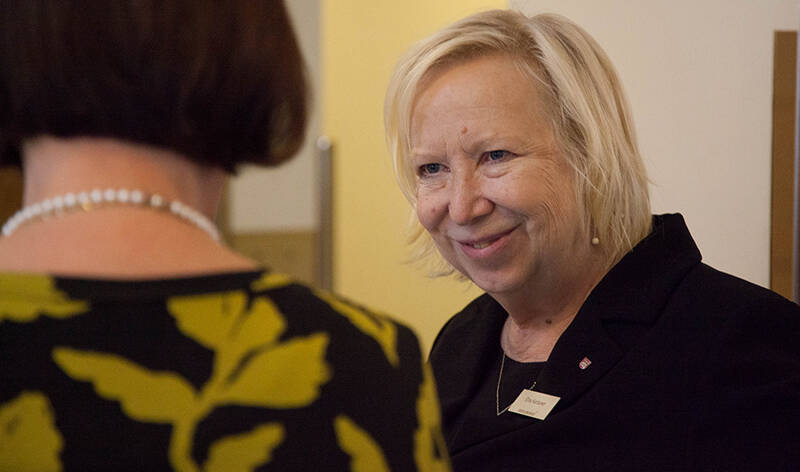 Hymyilevä Elina Karttunen juttelee kuvassa selin olevan naisen kanssa.