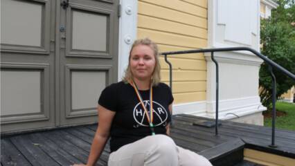 Nainen istuu kirkon portailla.