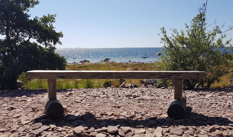 Tyhjä penkki maisemassa.
