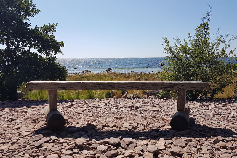 Tyhjä penkki maisemassa.