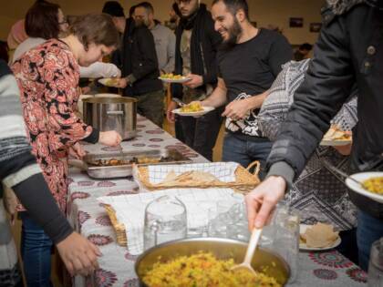 Lunch queue, where people take food from serving dishes placed on the table.