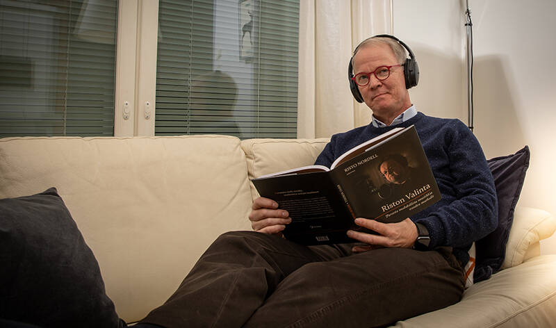Uni- ja musiikkilääkäri Miikka Peltomaa loikoilee nahkasohvalla kuunnellen musiikkia kuulokkeilla ja lukien kirjaa samalla. Hän korjaa silmälasiensa asentoa ja katsoo kohti lempeästi.