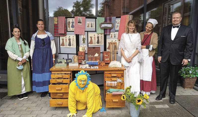 Vanhoihin vaatteisiin pukeutuneita henkilöitä ja leijona-asuinen hahmo poseeraavat.