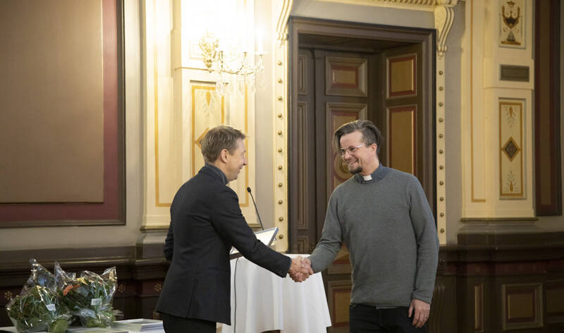 Apulaispormestari Matti Helimo kättelee pastori Olli Viljakaista Raatihuoneella.