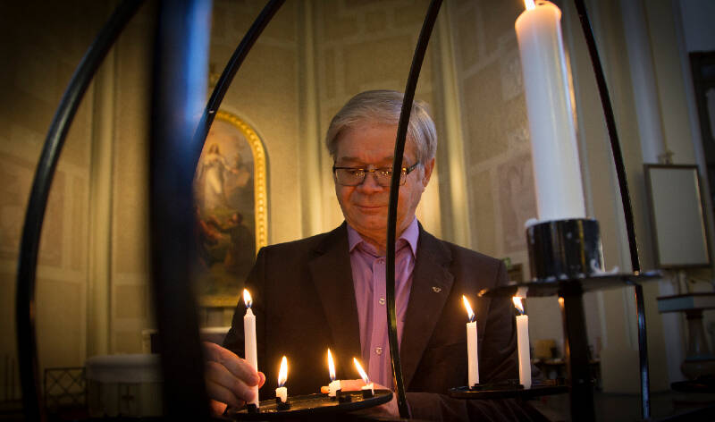Paavo Kettunen sytyttää kynttilää lähetyskynttelikköön.