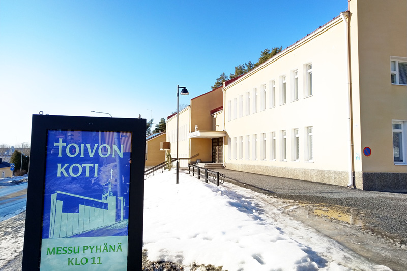 Pispalan kirkko, etualalla valomainos Toivon koti, messu pyhänä klo 11.