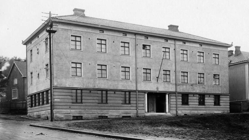 Mustavalkoinen kuva vanhasta kivitalosta.