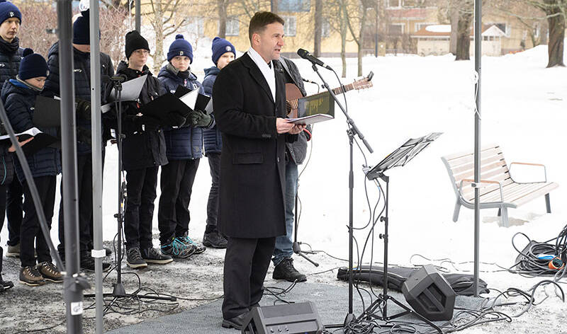 Tuomiorovasti Silfverhuth pitää puhetta lumisessa Kiovanpuistossa.