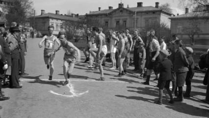 Vanhassa valokuvassa TKT:n joukkue vaihtaa viestikapulaa.