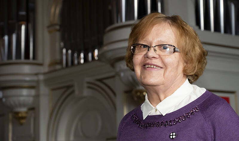 Lähikuva vanhemmasta henkilöstä kirkossa, taustalla urut.