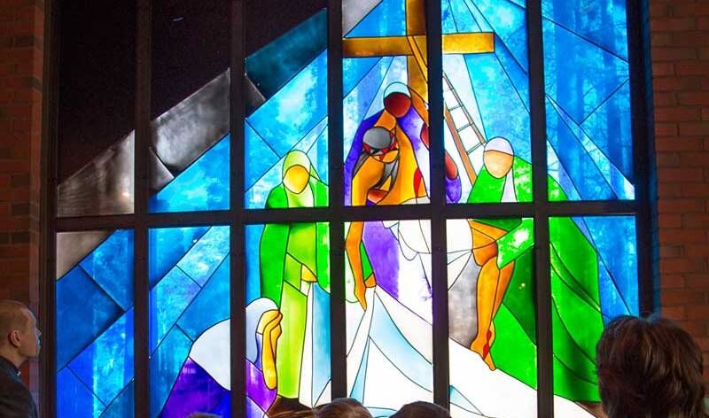 Via-dolorosa lasimaalaus, jossa kolme naista kantaa jeesusta valkoiseeen liinaan käärittynä.