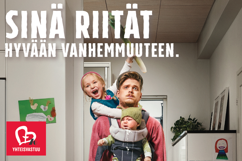 Vuoden 2020 Yhteisvastuukeräyksen mainoksessa on nuori perheenisä useamman lapsen pyörityksessä. Hän on väsynyt. Kuva on humoristinen.