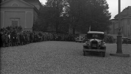 Valtava ihmisjoukka on pakkaantunut Vanhan kirkon eteen ja Keskustorin puoleiselle seinälle katsomaan mukulakivillä ajavaa autoa.